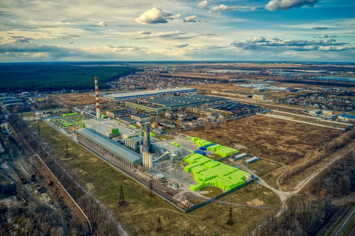 Planta de hidrógeno verde con electrolizadores y tanques de almacenamiento junto a un campo de paneles solares